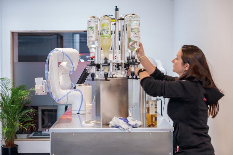 Woman works on the Cotender robot