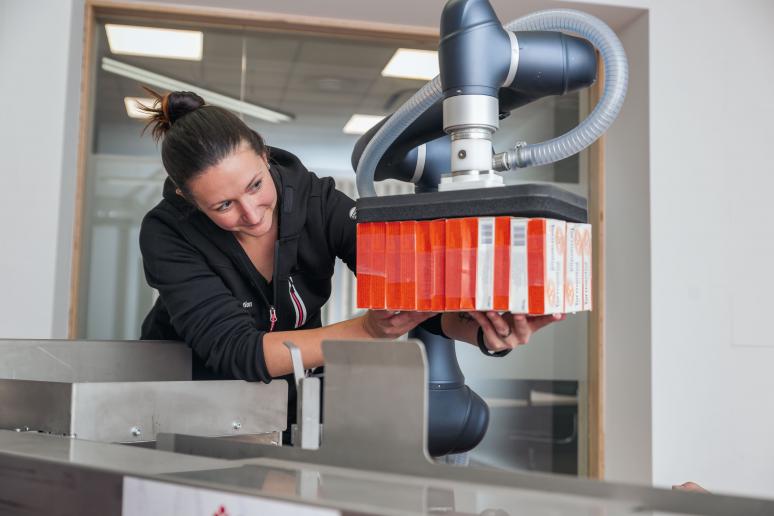 Woman works on robot for packaging